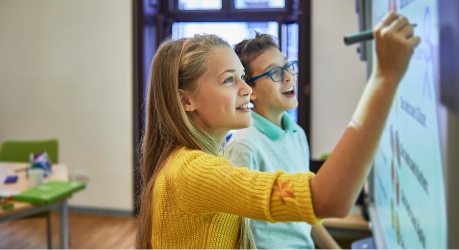 Children writing on a whiteboard