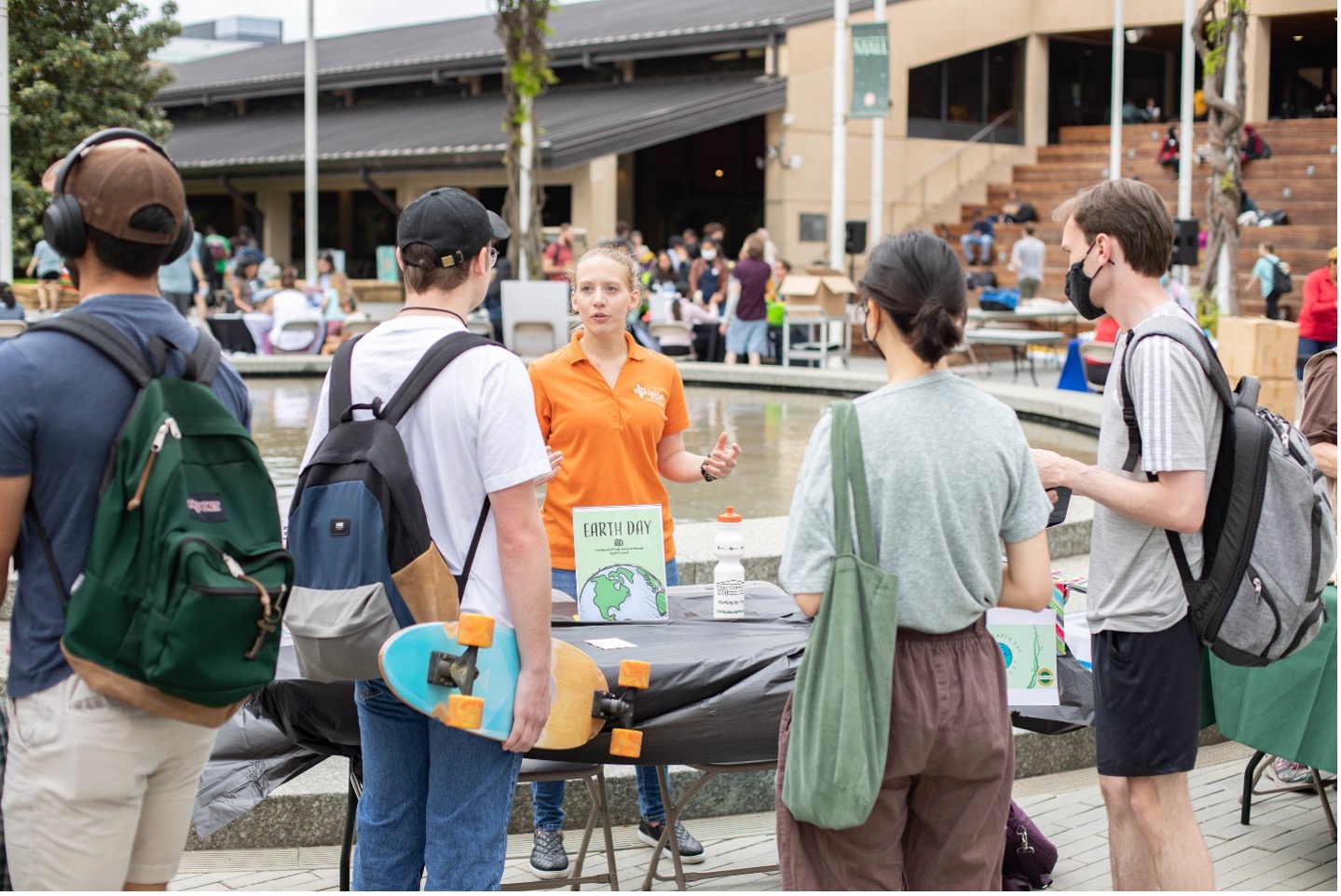 Students talking with a volunteer at the Trellis Plaza on Earth Day.