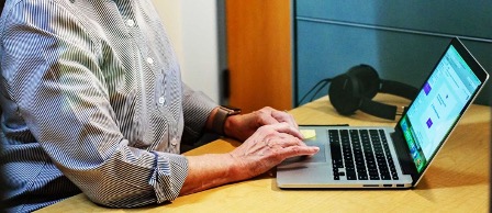 An employee types on a laptop