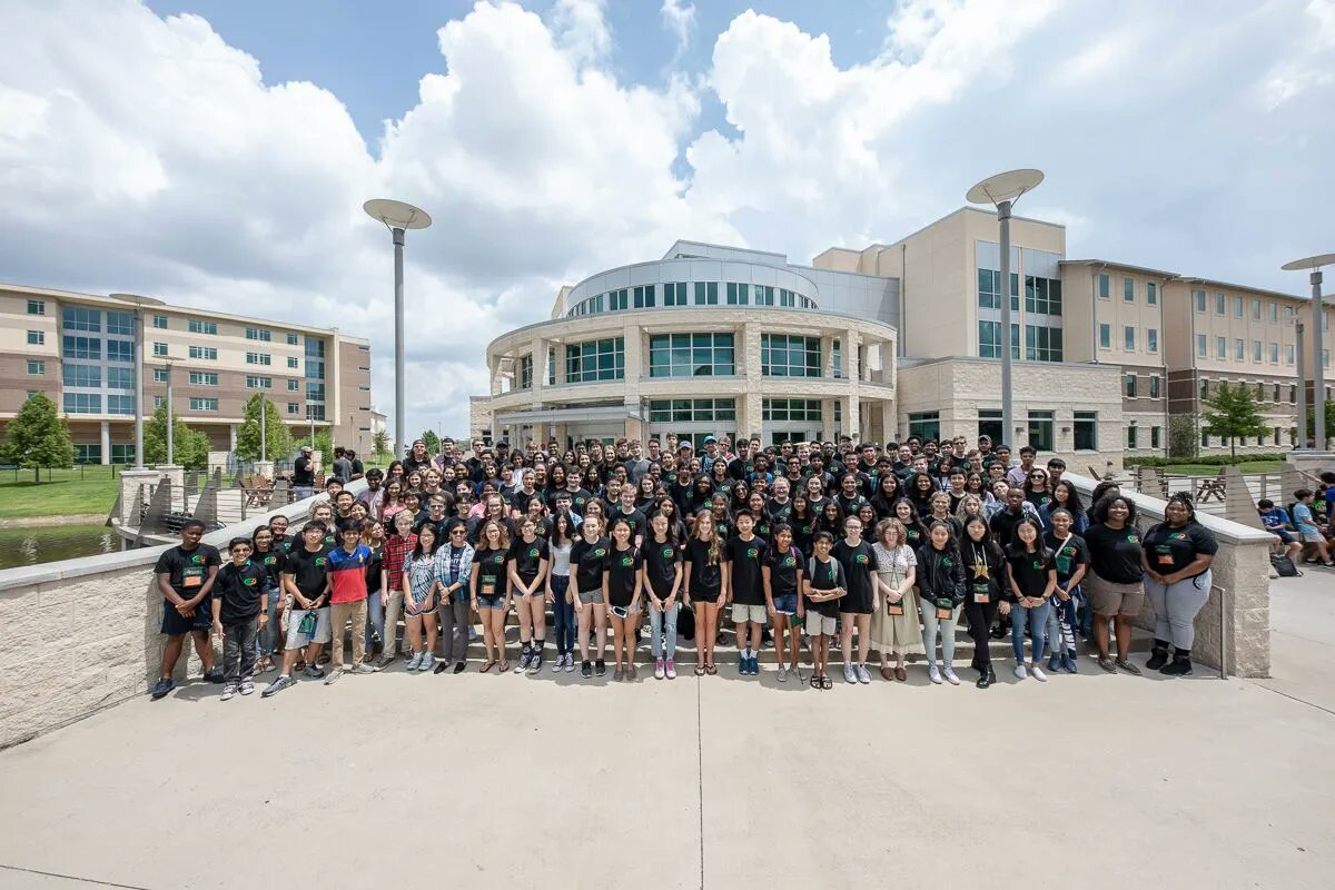 Dozens of summer camp participants in front of a residence hall.