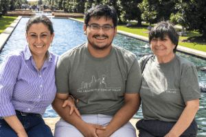 Family pose with a student on campus